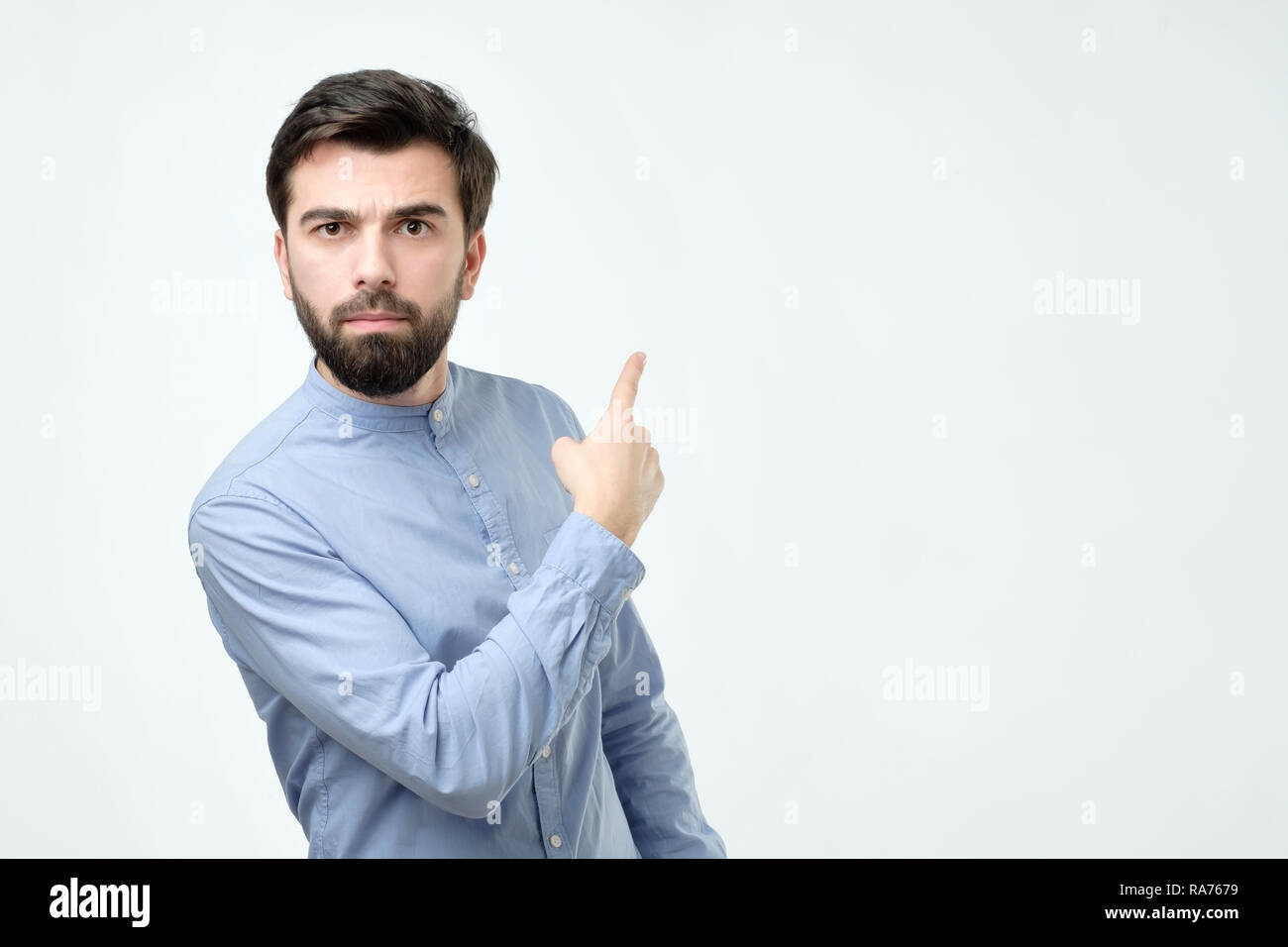 Stylish handsome young hispanic man pointing aside. Stock Photo