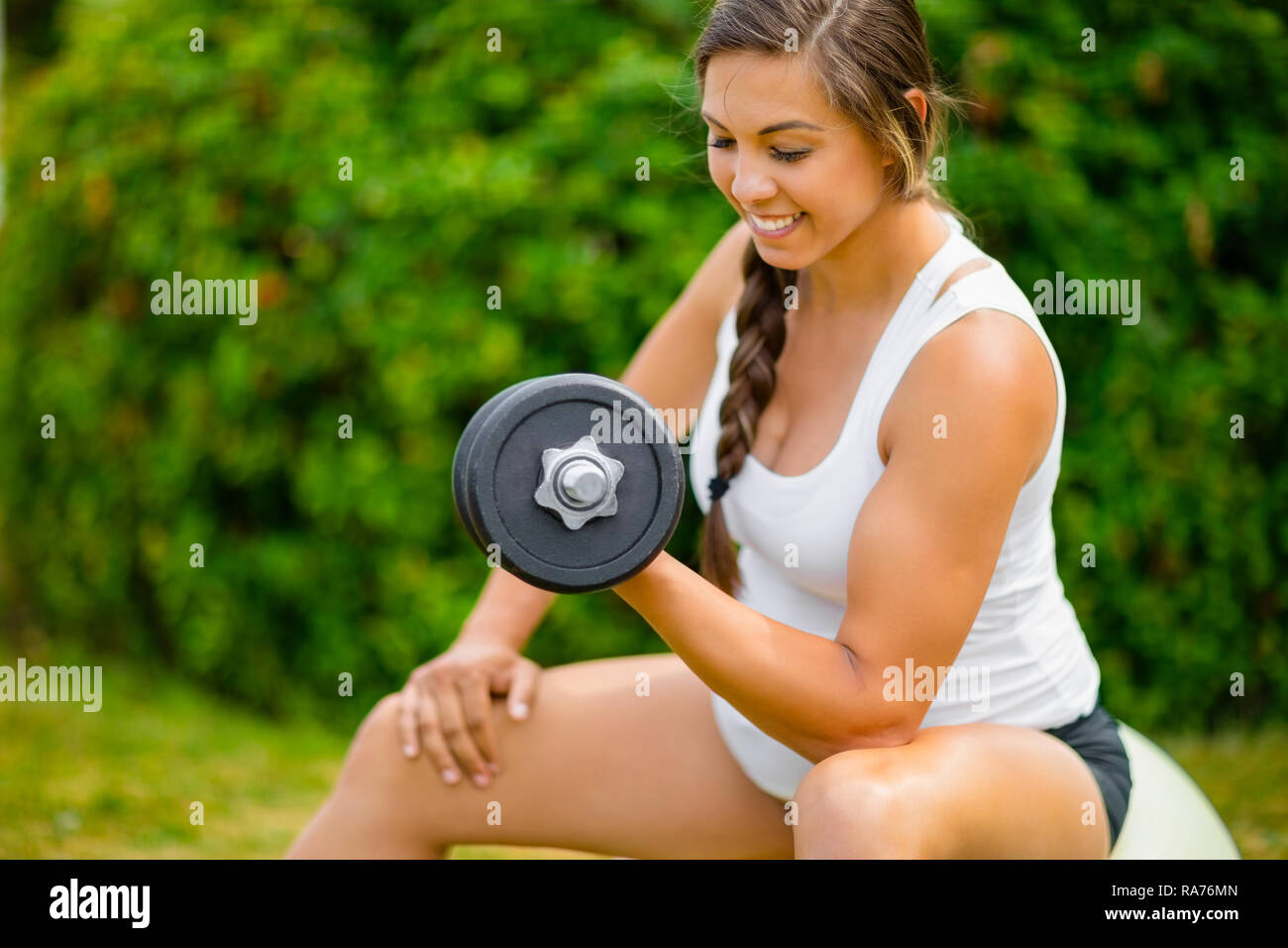 Expectant Female Exercising With Dumbbells To Strengthen Arms In Stock Photo