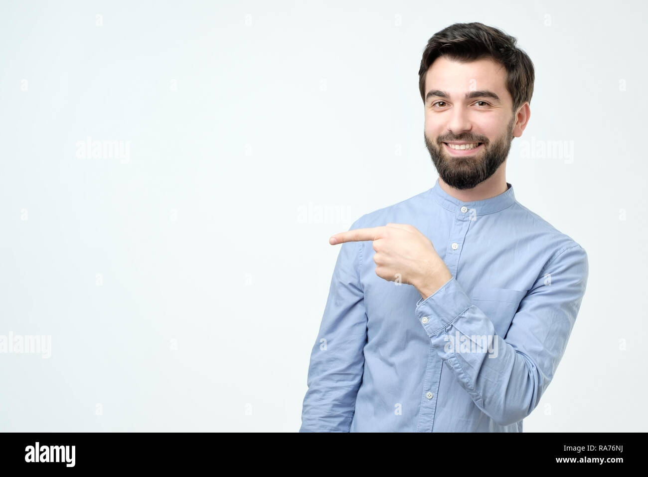 Stylish handsome young hispanic man pointing aside. Stock Photo