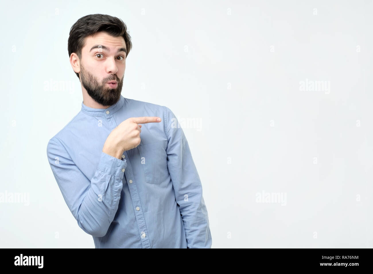 Stylish handsome young hispanic man pointing aside. Stock Photo