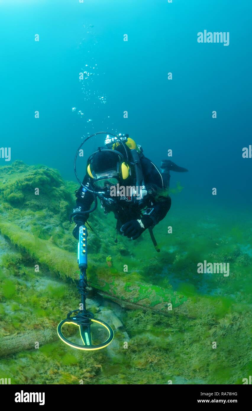 Diver with the metal detector looks for a treasure under water, lake Baikal, Siberia, Russia