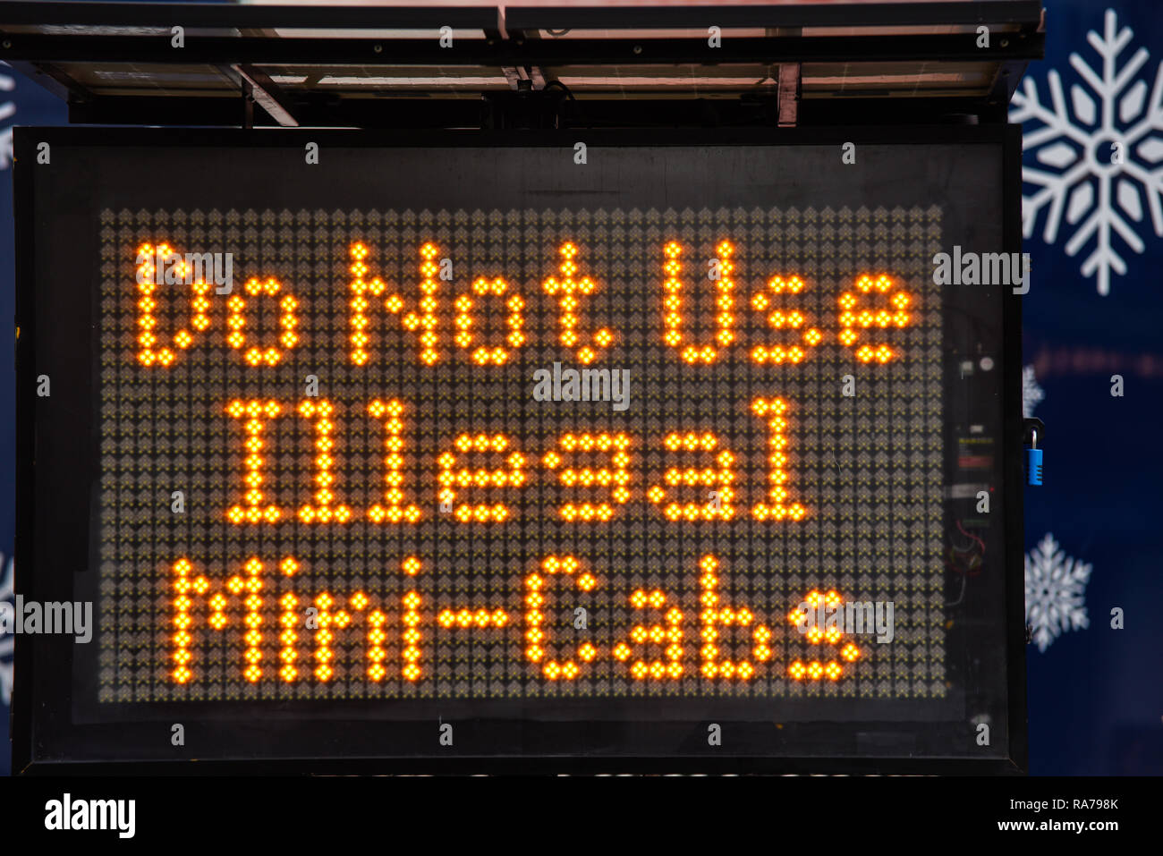 Do not use illegal mini cabs matrix sign for New Year's Eve revelers in London, UK. Warning message Stock Photo