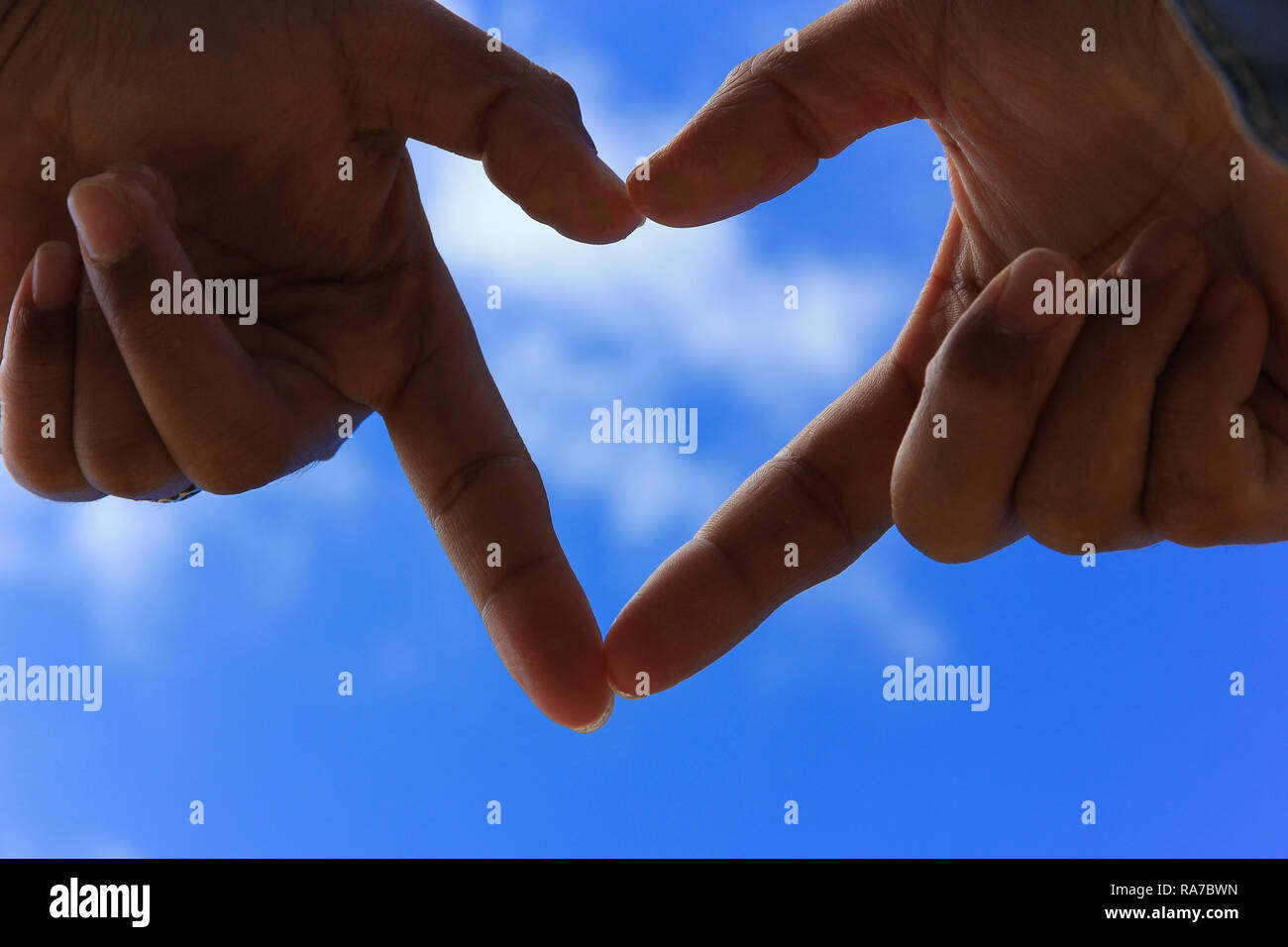 hands making a heart shape with blur blue sky. Love concept Stock Photo ...