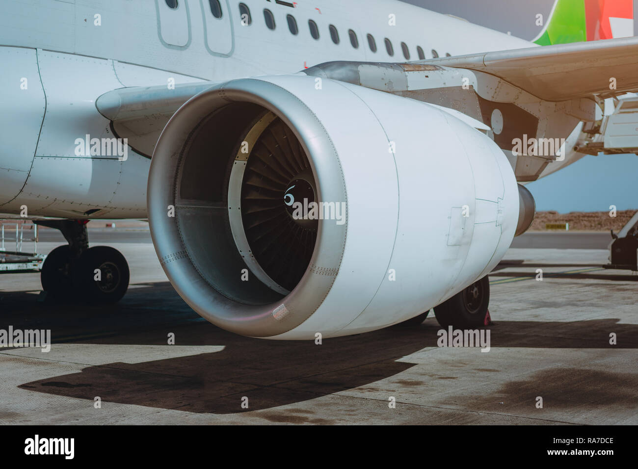 Turbine of passenger jet that waiting for departure in airport in warm afternoon light. Stock Photo