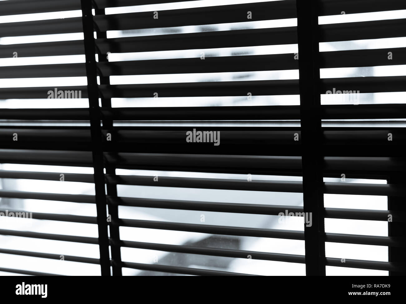 Opened plastic blinds in black and white. Plastic window with