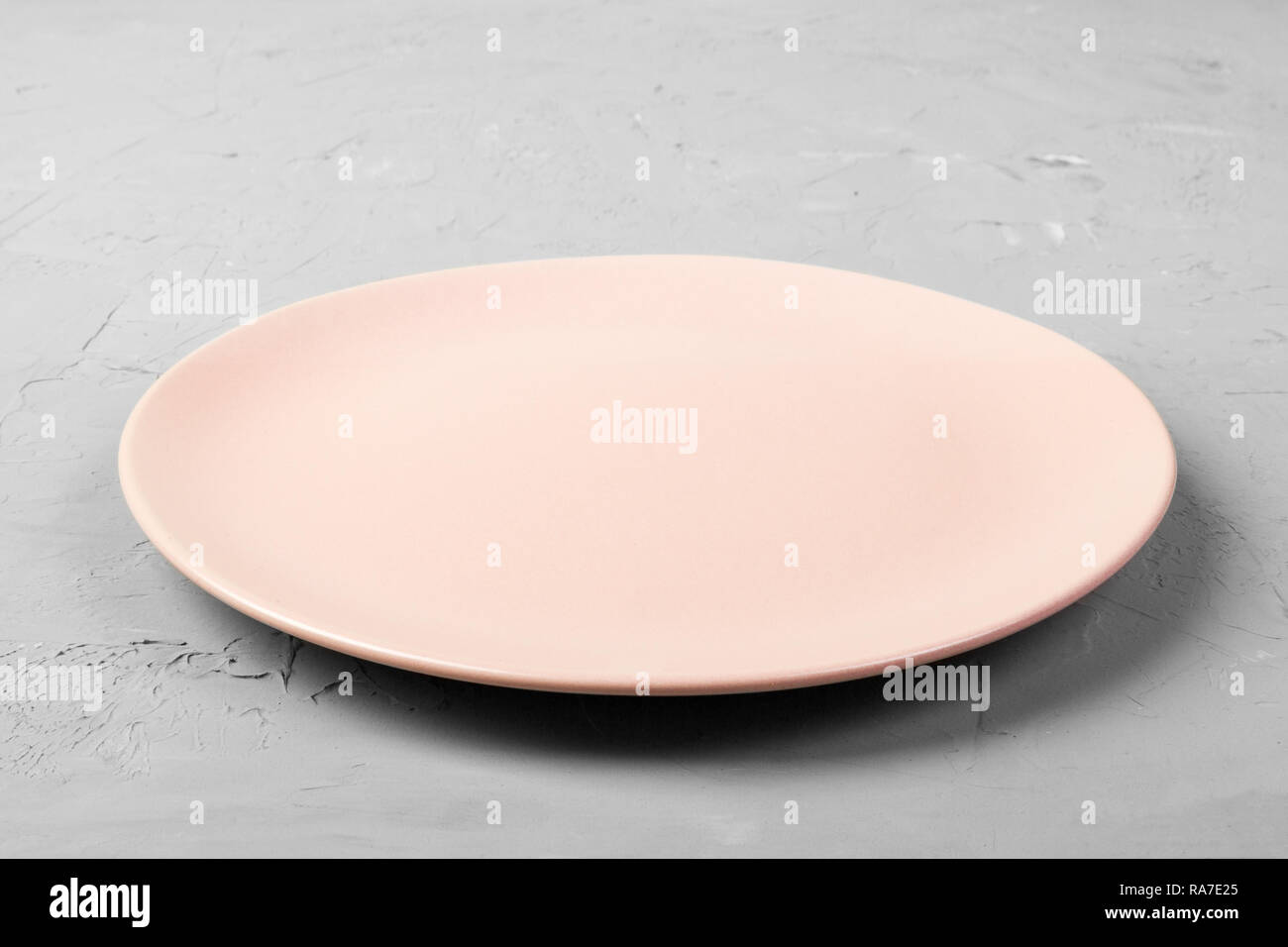 Top view of matte round empty rose plate on grey cement background copy ...