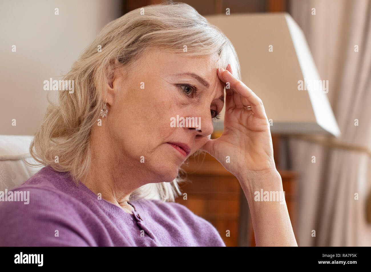 Side View Of Depressed Senior Woman At Home Stock Photo