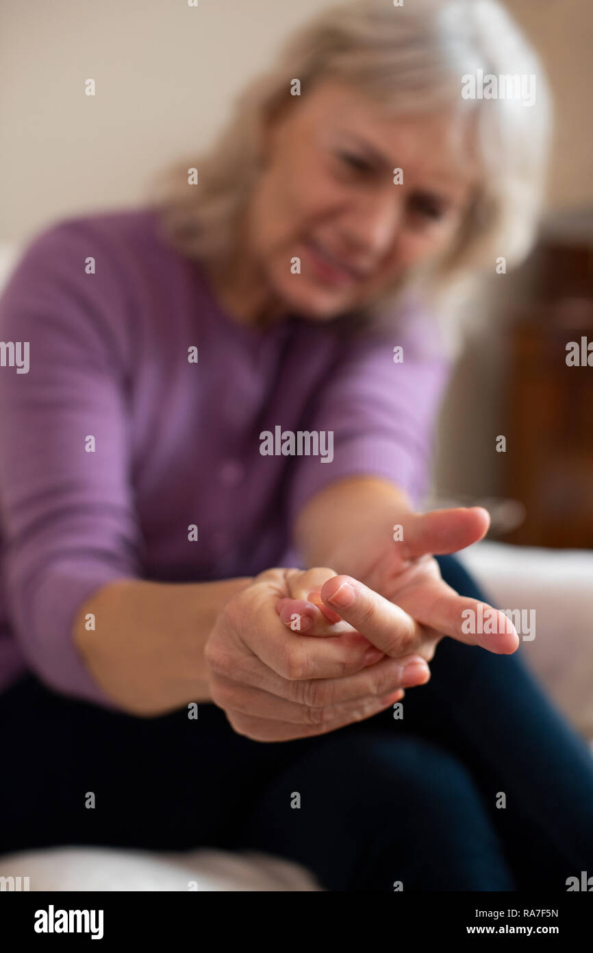 Senior Woman At Home Suffering With Arthritis Stock Photo