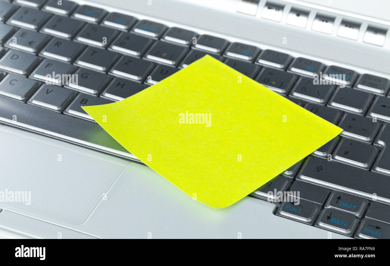 Empty yellow sticky paper note on laptop keyboard with copy space Stock Photo