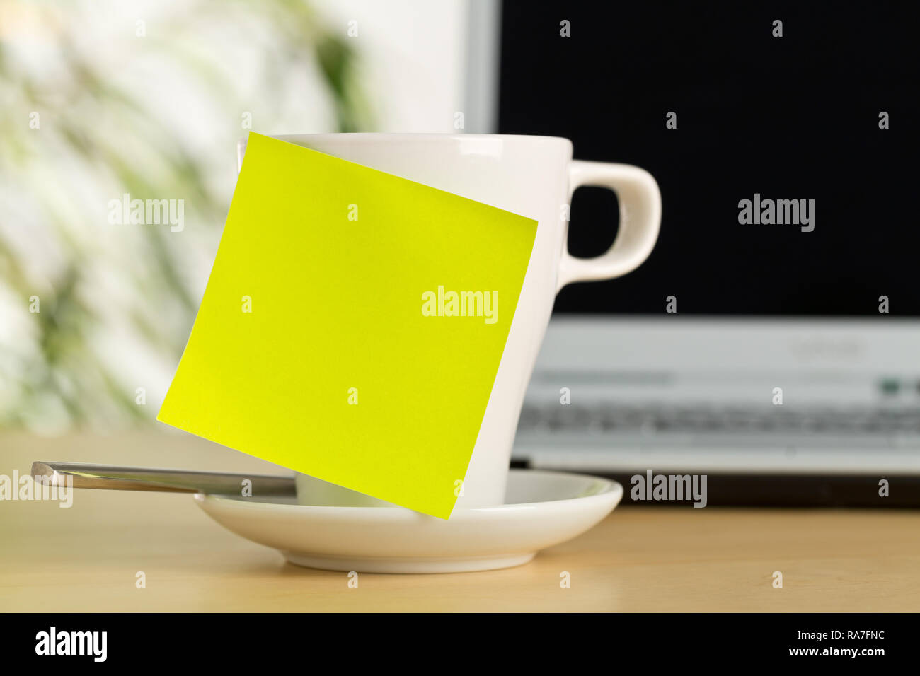 Yellow empty sticky note on white coffee or tea cup with copy space in ...