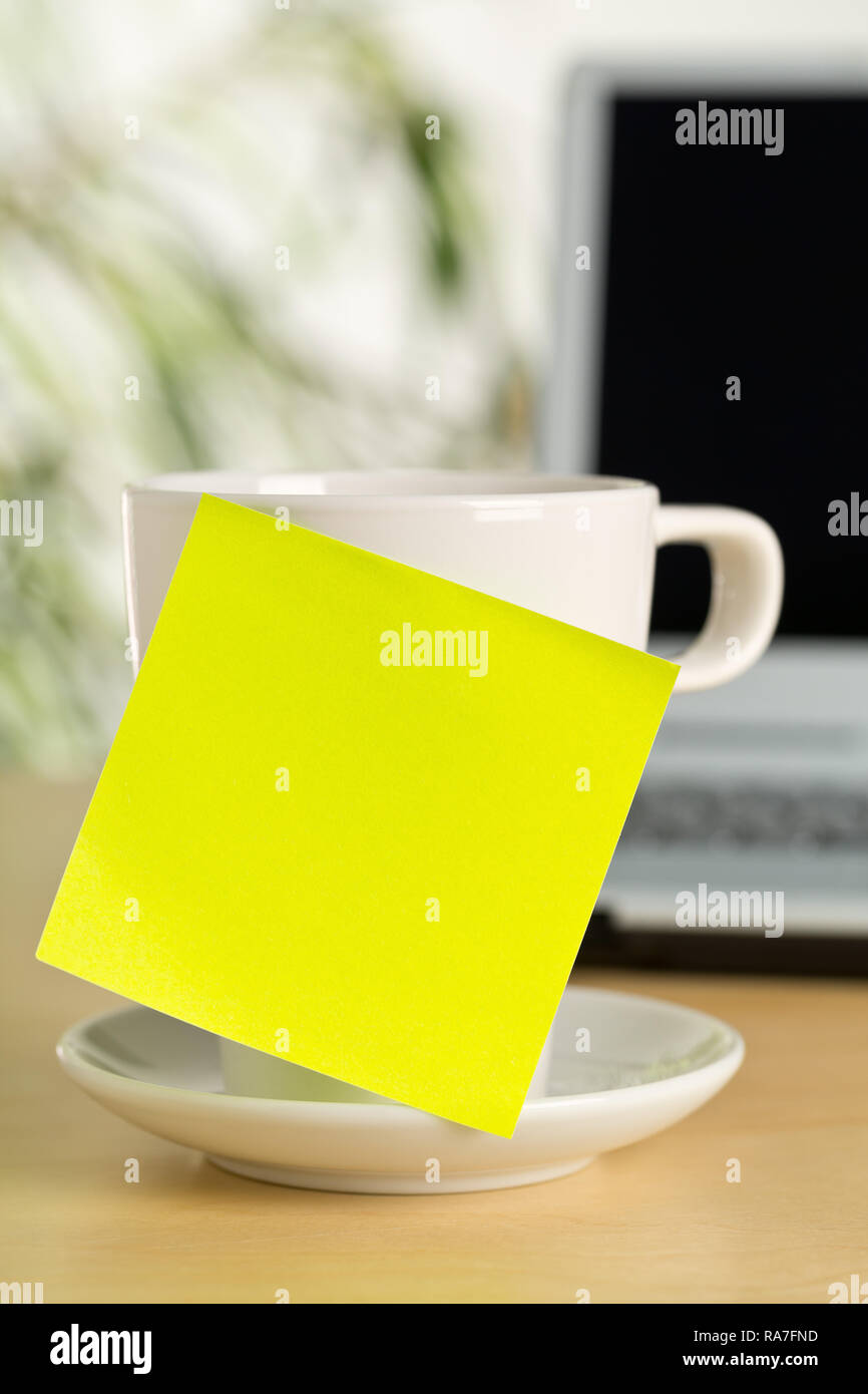 Yellow empty sticky note on white coffee or tea cup with copy space in ...