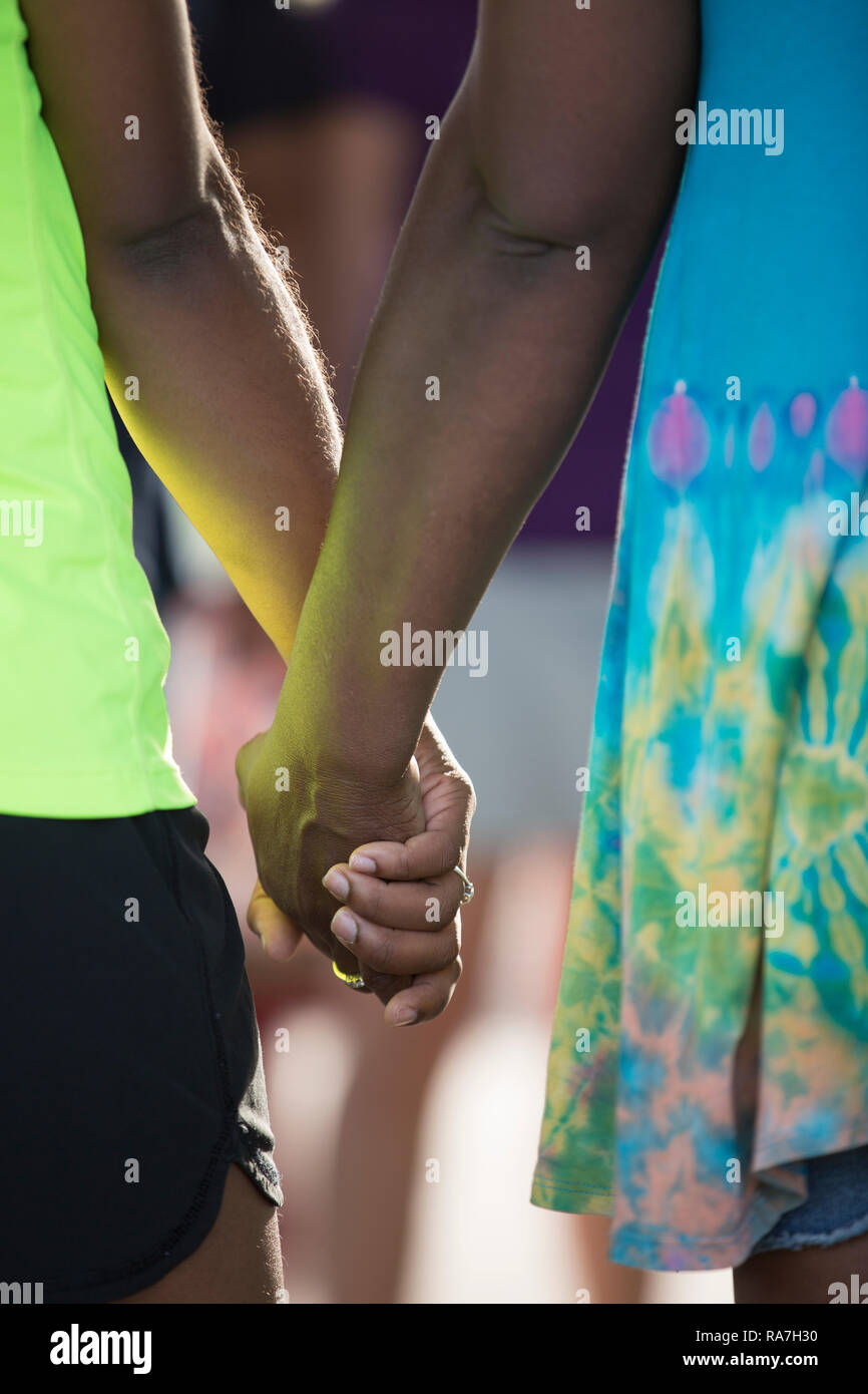 A closeup of two African American women standing next to each other holding hands Stock Photo