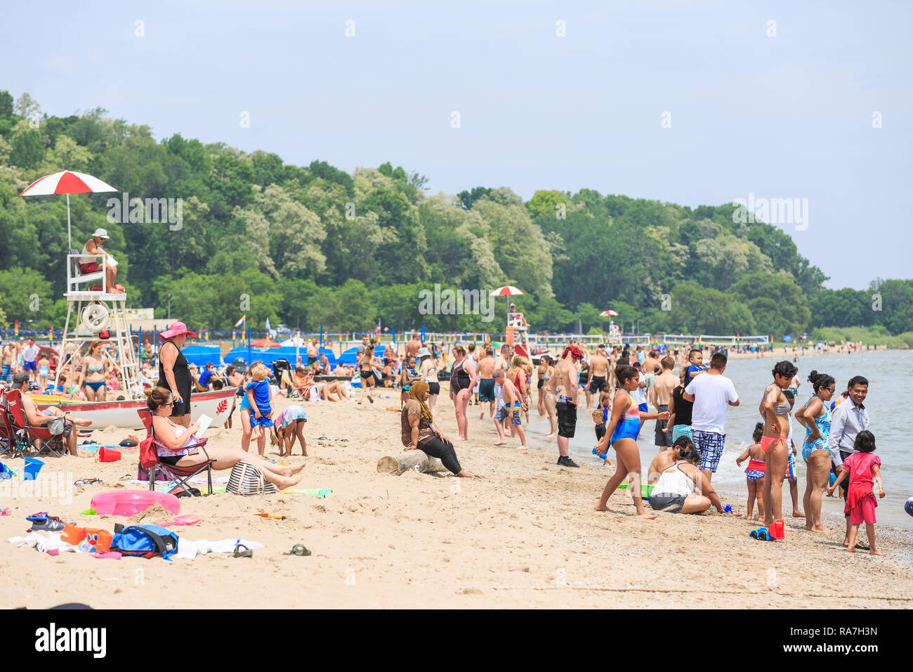 crowds of people fill a beach on a hot summer day Stock Photo