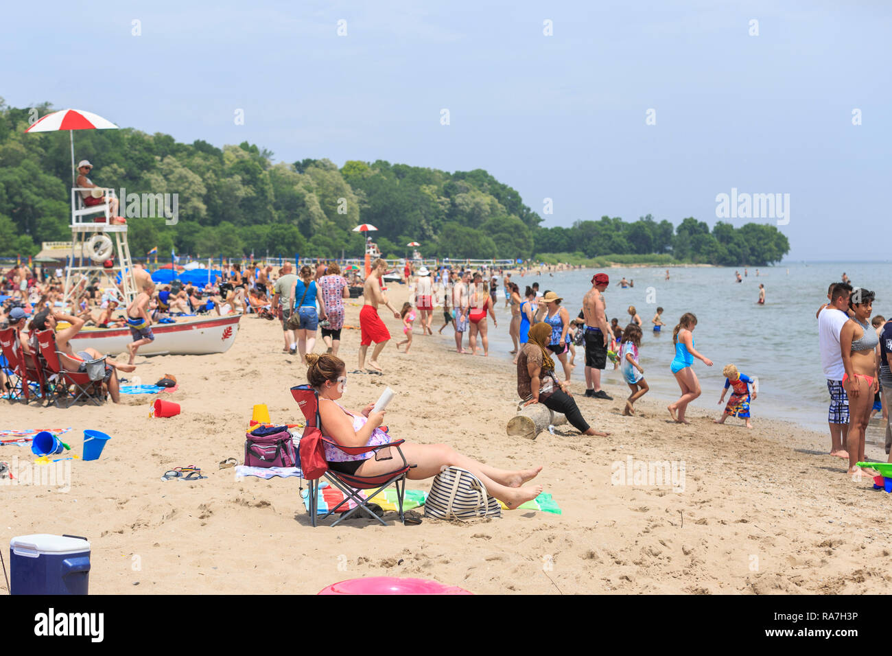 crowds of people fill a beach on a hot summer day Stock Photo