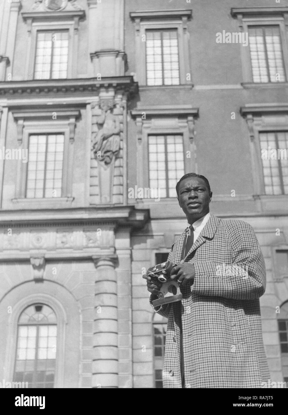 Nat King Cole. March 17, 1919 - Febryary 15, 1965. American jazz pianist and singer. Pictured here during a visit to Stockholm Sweden 1954 when performing there. He is sightseing in the Swedish capital and visits the Royal Castle, and snaps some pictures with his camera. Photo Kristoffersson. Stock Photo