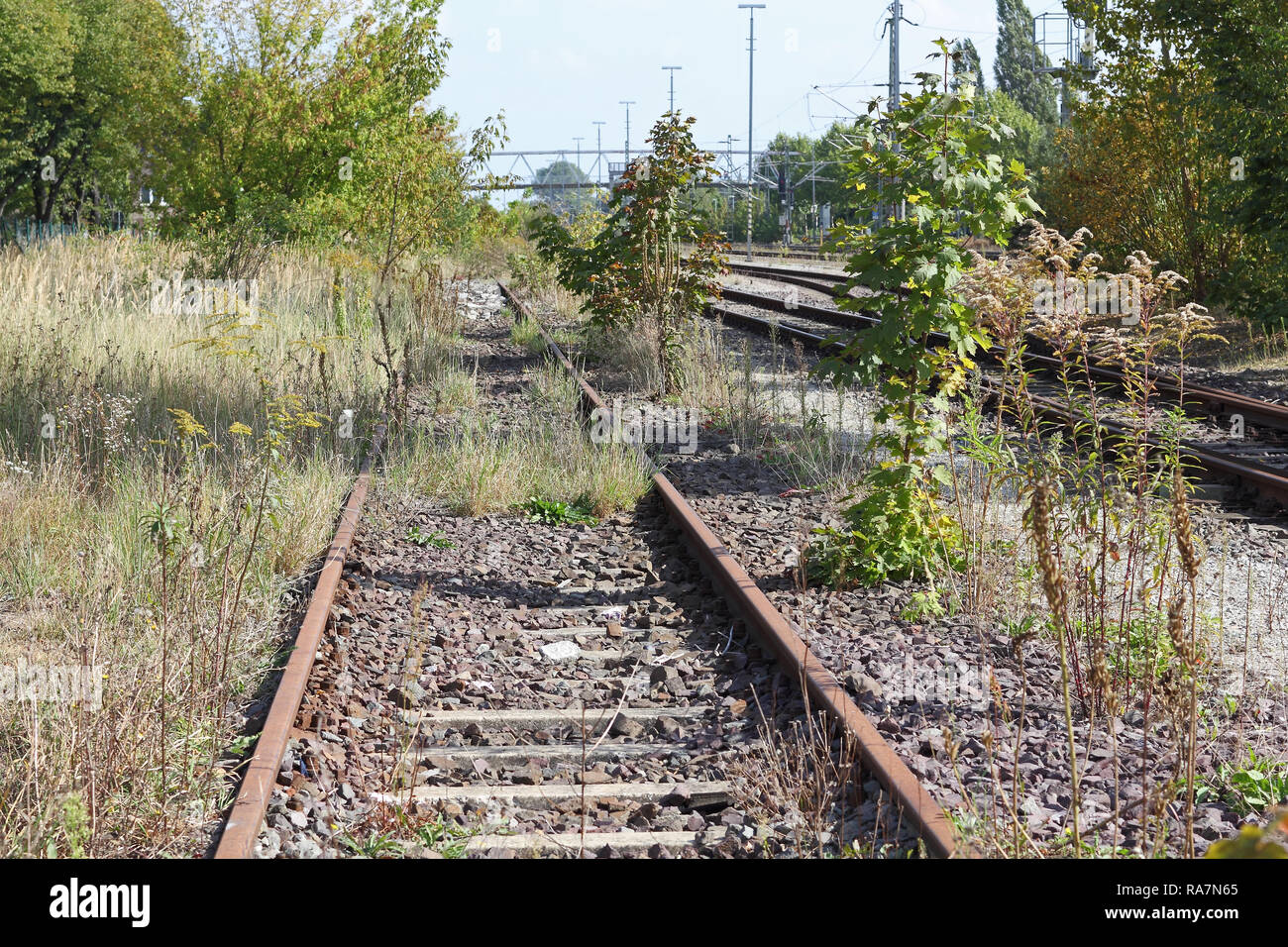 A decommissioned railway line beside tracks in operation Stock Photo