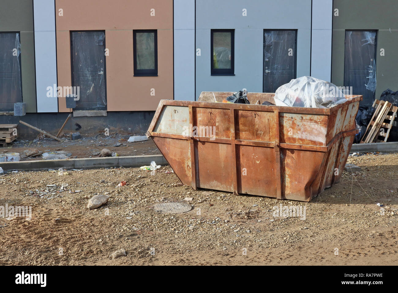 The old rusty steel container on construction site filled with wast and ...