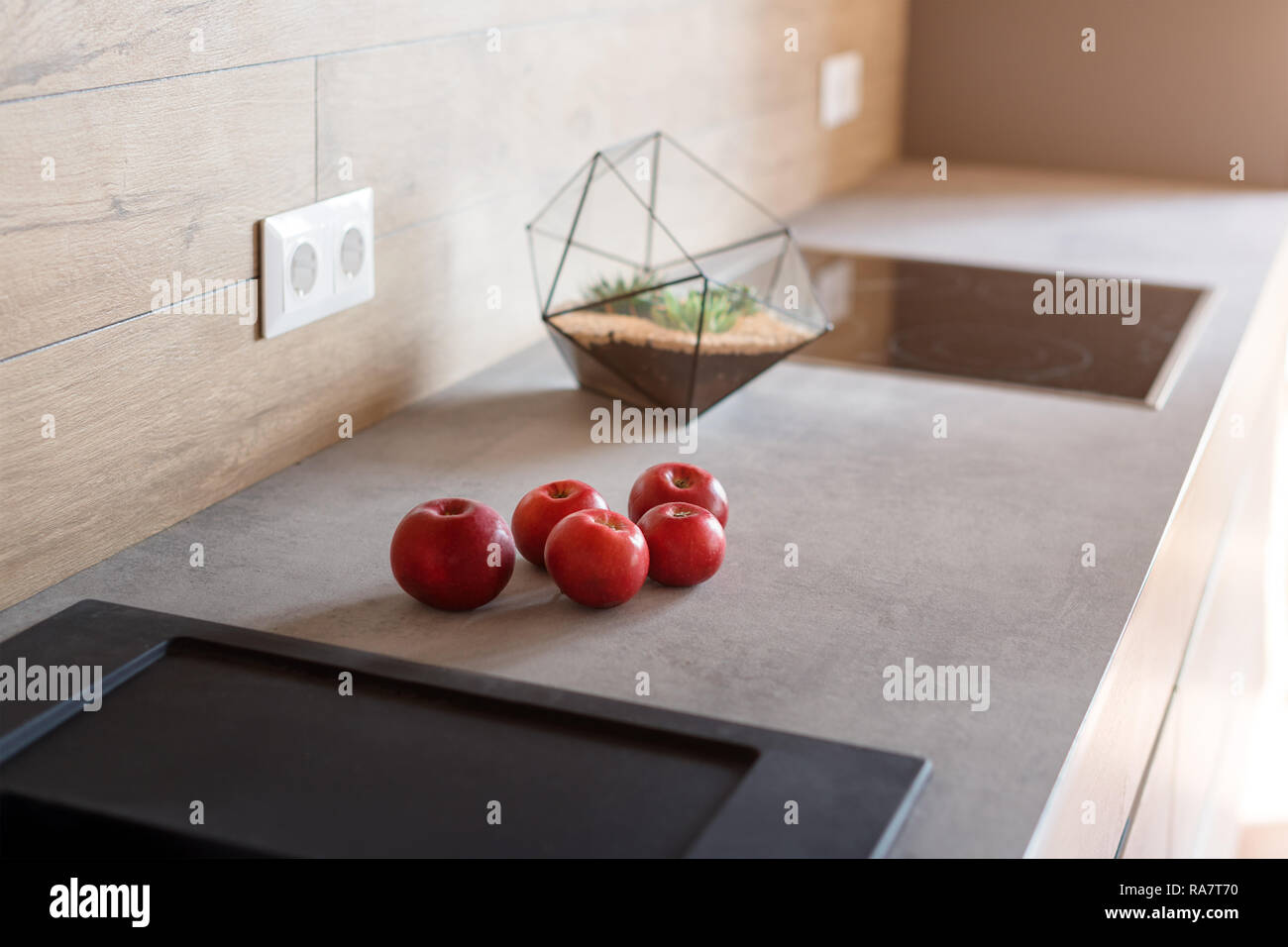 Kitchen table with red apples. Modern kitchen interior, close up Stock