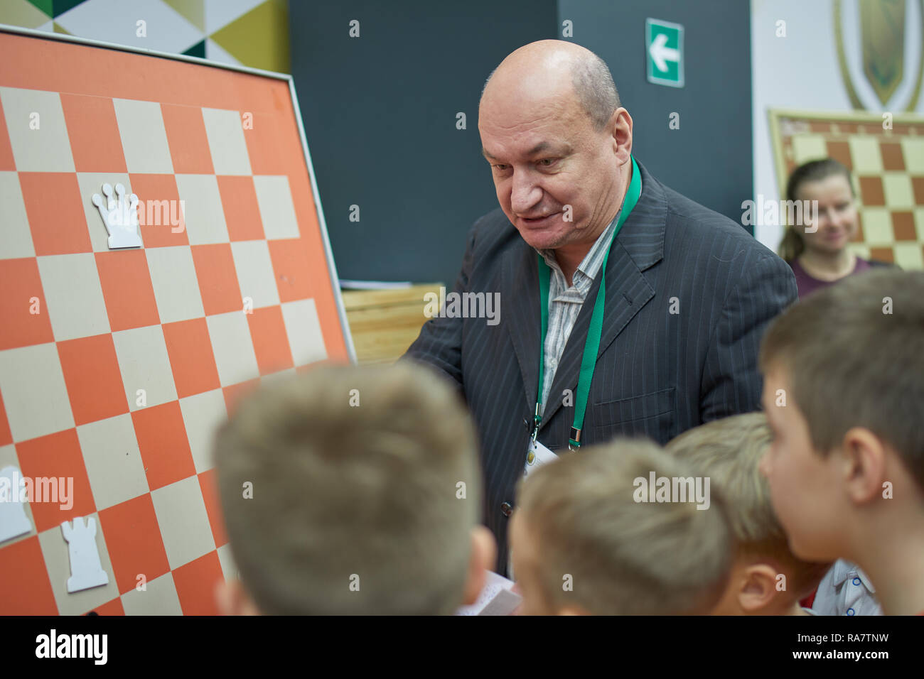 St. Petersburg, Russia - December 27, 2018: Three-time world champion for chess composition Oleg Pervakov gives a lesson to children during World Rapi Stock Photo