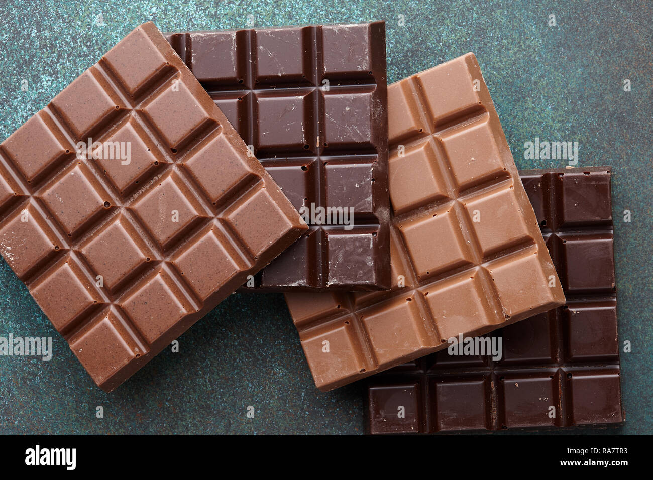 Various chocolate bars pile on wooden background Stock Photo