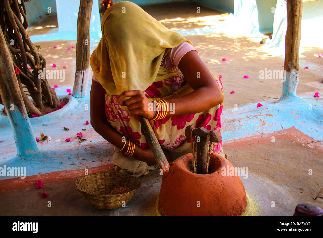 Traditional way of grinding grain in a rural village,near Khajuraho,India Stock Photo