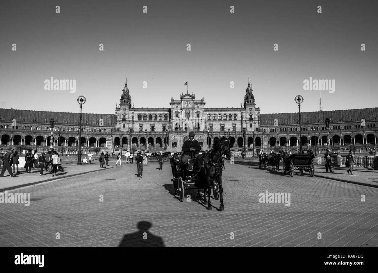 A carriage moving in the middle of Plaza de España, a square in Seville, capital of Andalusia, Spain. This square was build in 1928. Stock Photo