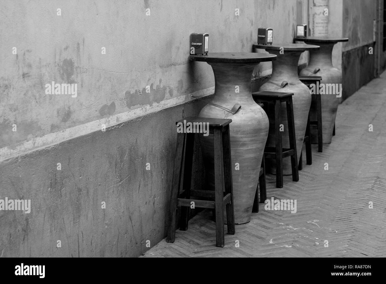 Three big empty vases used as seats outside a restaurant in Seville, Spain. Stock Photo