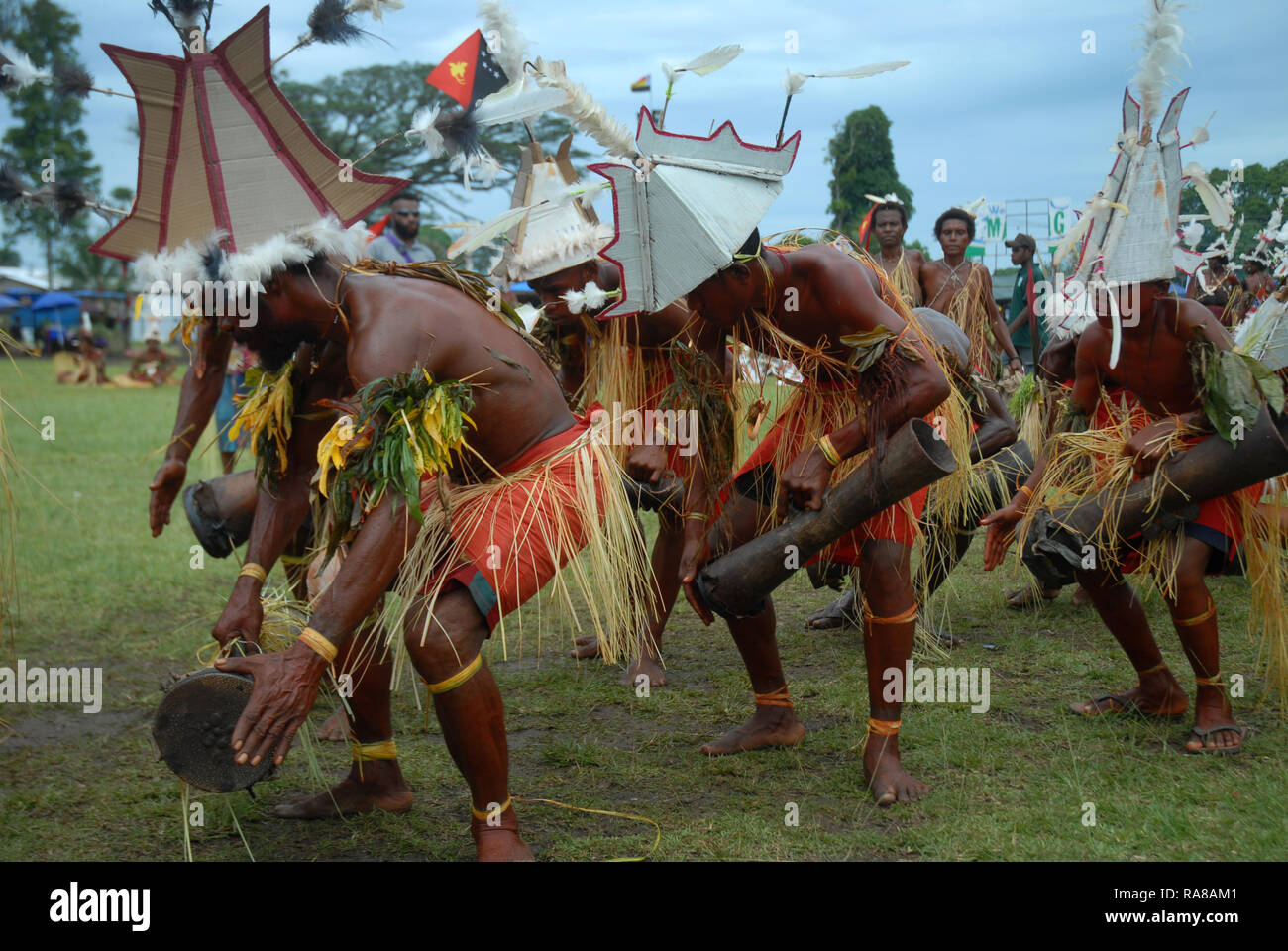 Colourfully dressed and face painted men singing and dancing at the annual Sing Sing in Madang, Papua New Guinea. Stock Photo