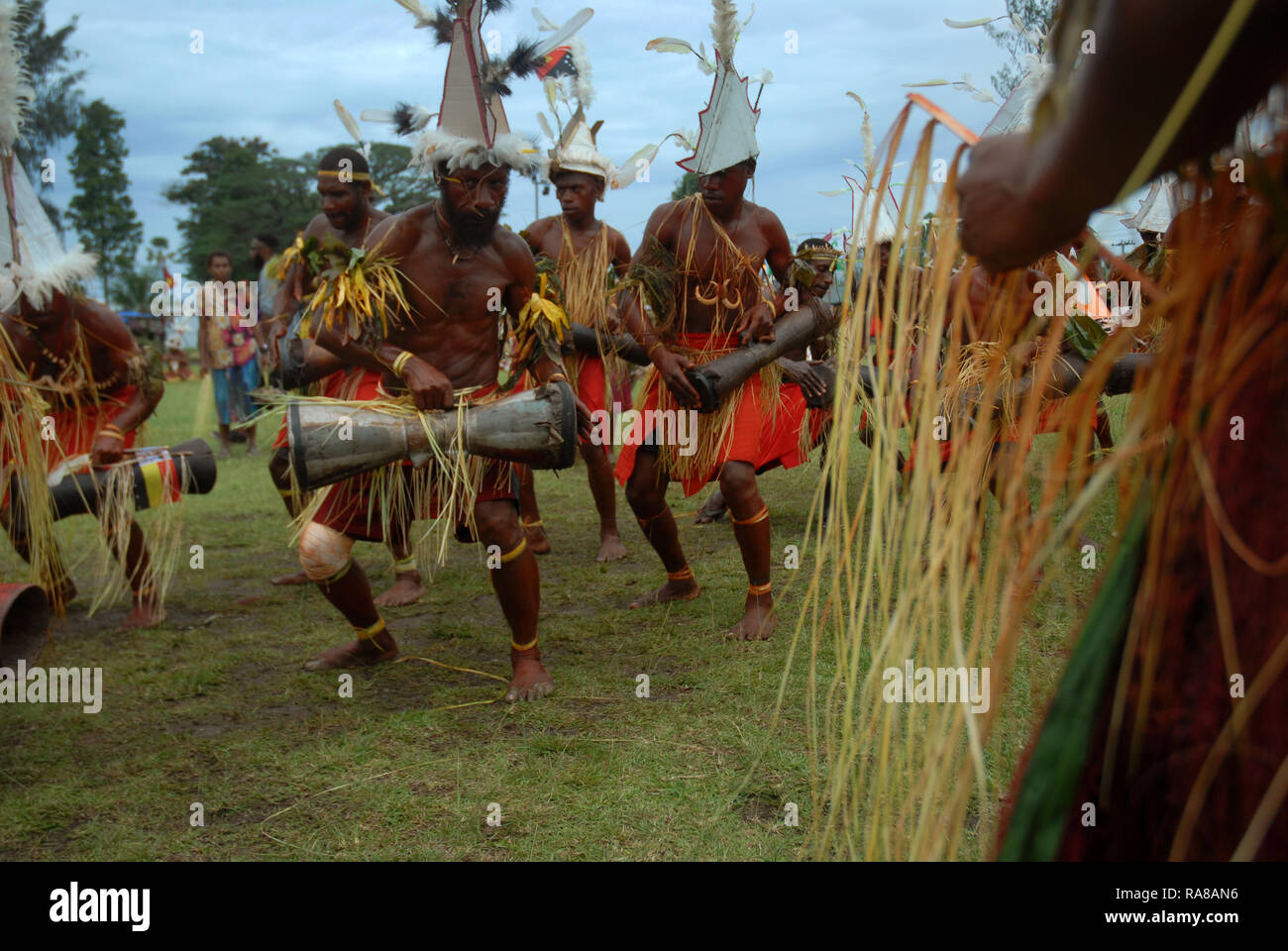 Colourfully dressed and face painted men singing and dancing at the annual Sing Sing in Madang, Papua New Guinea. Stock Photo
