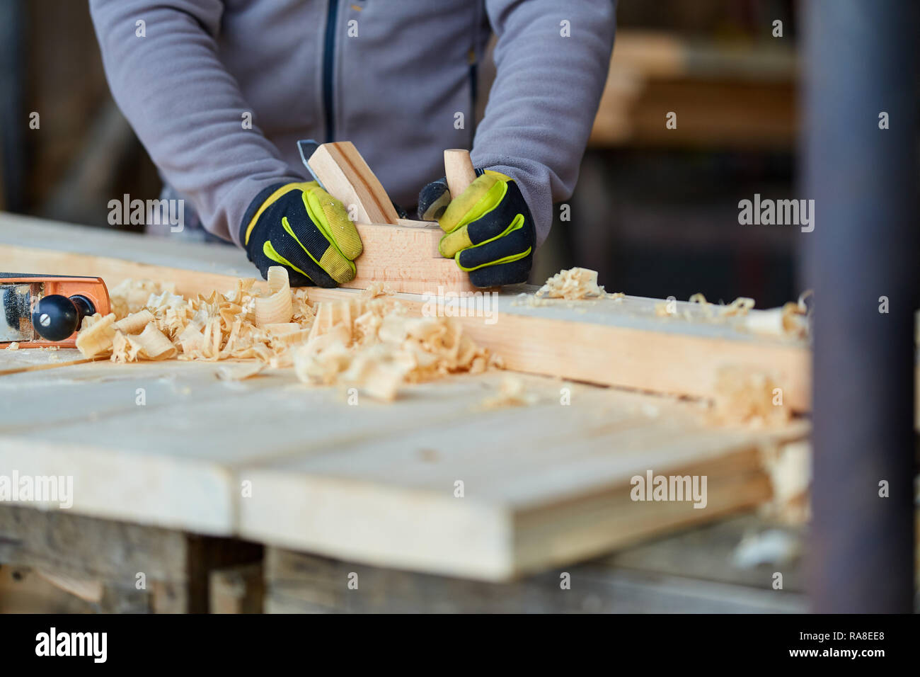 Woodworking - man using hand planer on a pine wood Stock Photo