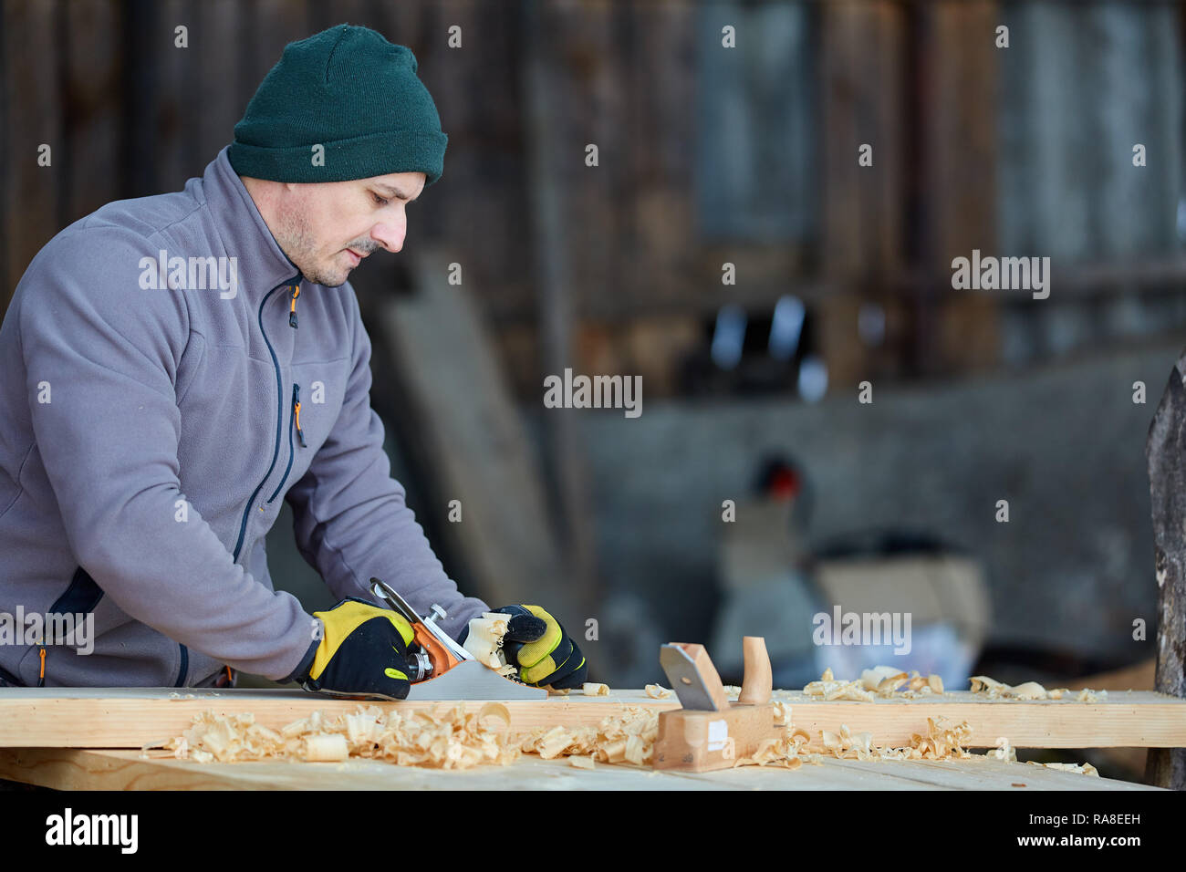 Woodworking - man using hand planer on a pine wood Stock Photo