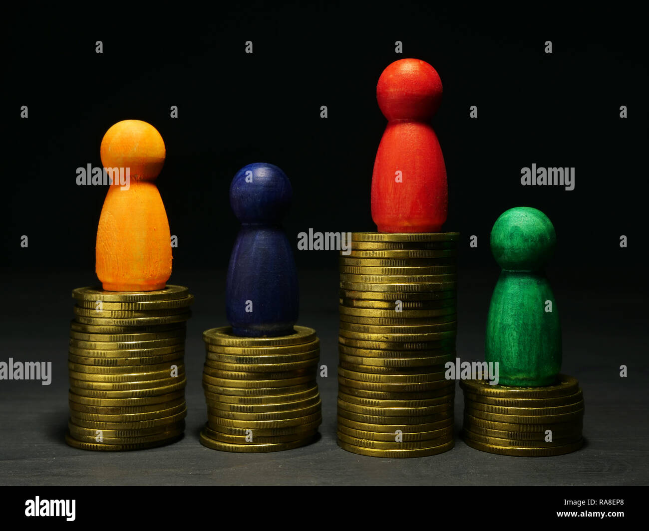 Wealth management and money savings. Wooden figures and coins. Stock Photo