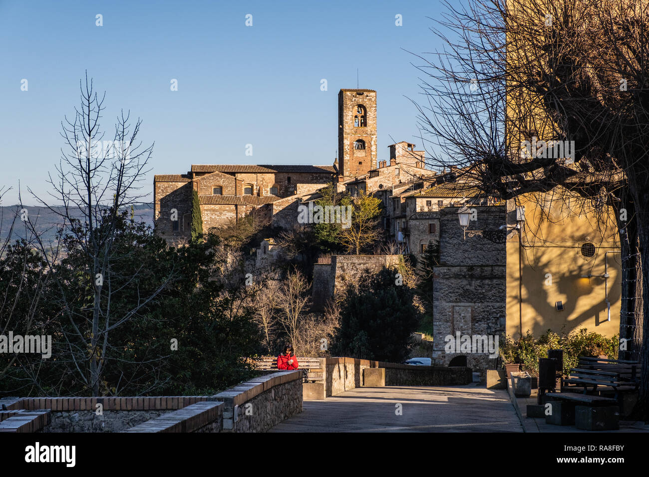 COLLE VAL D’ELSA, ITALY - DECEMBER 26, 2018: Unknown woman and panoramic view with the towers of the church of Santa Caterina and the Praetorian Palac Stock Photo