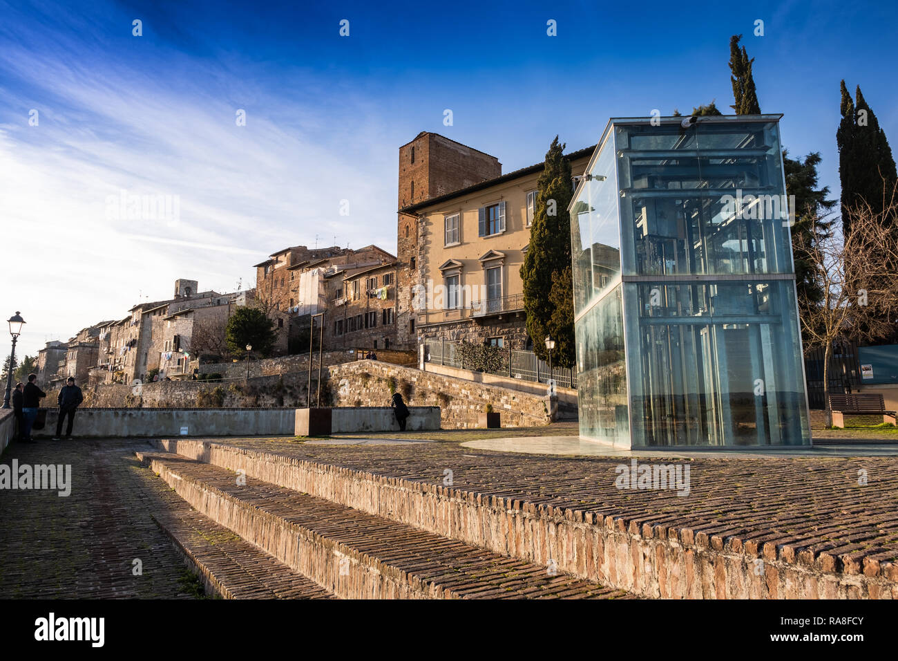 COLLE VAL D’ELSA, ITALY - DECEMBER 26, 2018: Two unknown people. The Baluardi with its crystal lift offer a panoramic view of the city in the historic Stock Photo