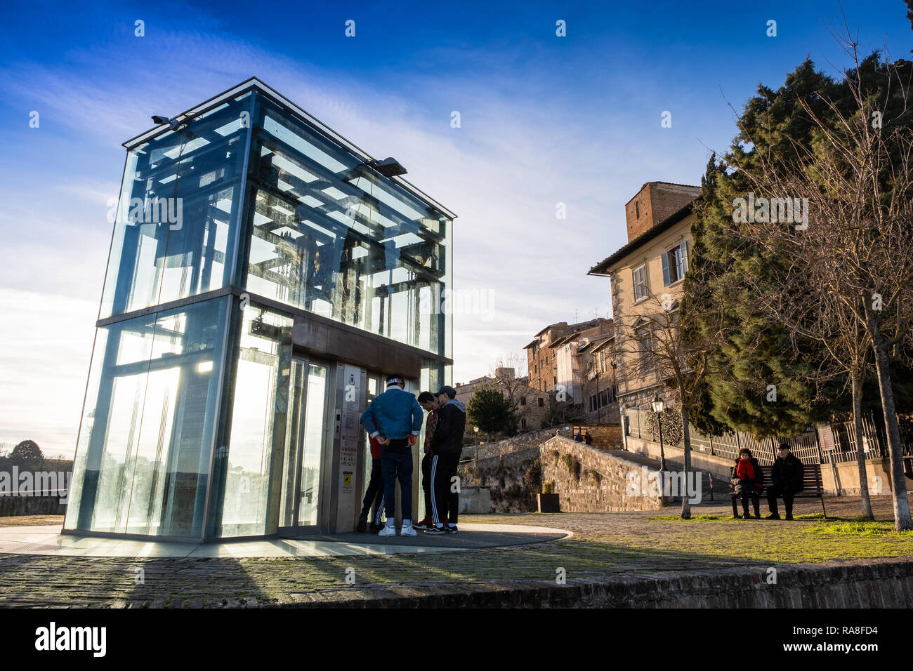 COLLE VAL D’ELSA, ITALY - DECEMBER 26, 2018: Two unknown people in the Baluardi with its crystal lift offer a panoramic view of the city in the histor Stock Photo