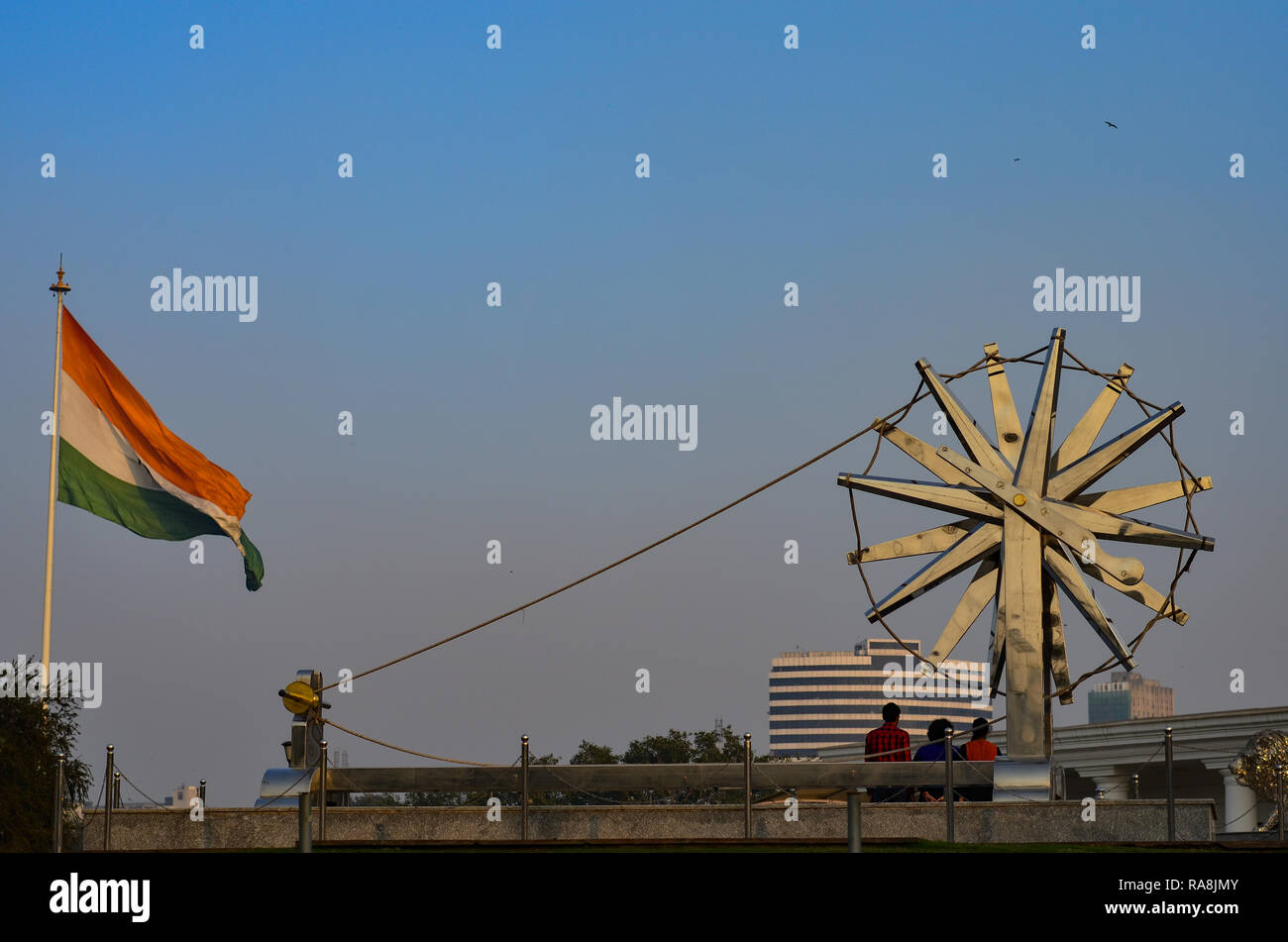 Giant spinning wheel against the backdrop of waving Indian tricolor in