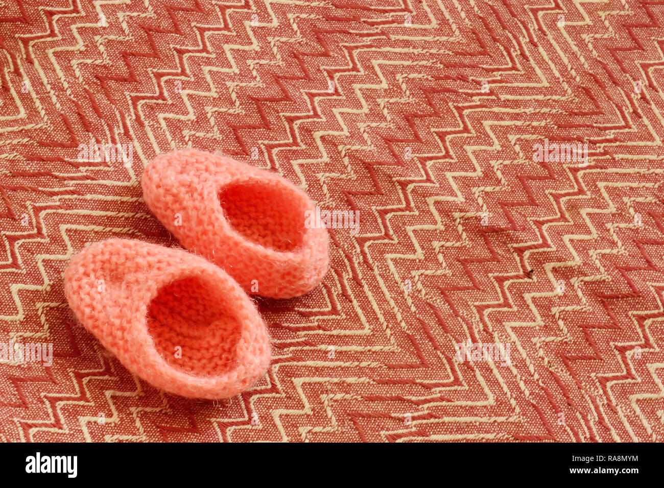 Cute pink knitted woolen shoes for little baby Stock Photo - Alamy