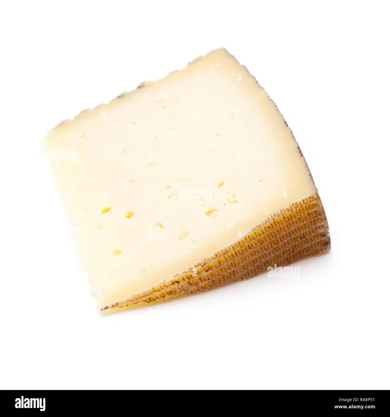 Spanish Manchego cheese made from sheep's milk it has a firm and creamy texture, isolated on a white studio background. Stock Photo
