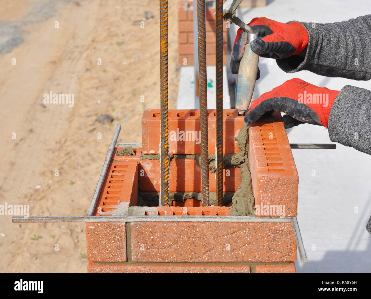 Bricklaying Closeup. Bricklayer hand holding a Putty Knife and Building