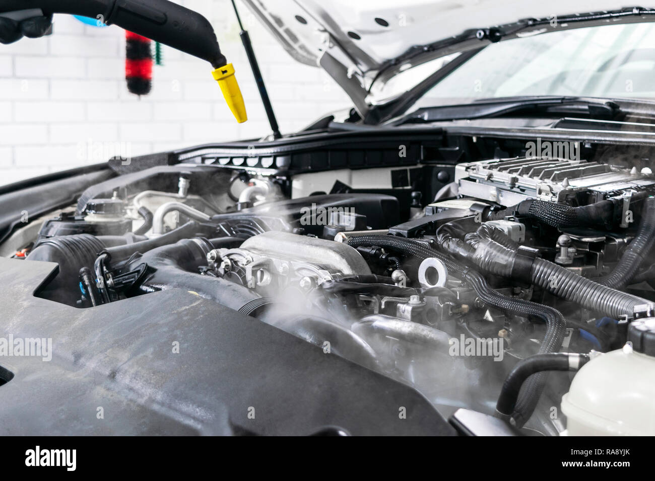 Car detailing. Car washing cleaning engine. Cleaning car using steam