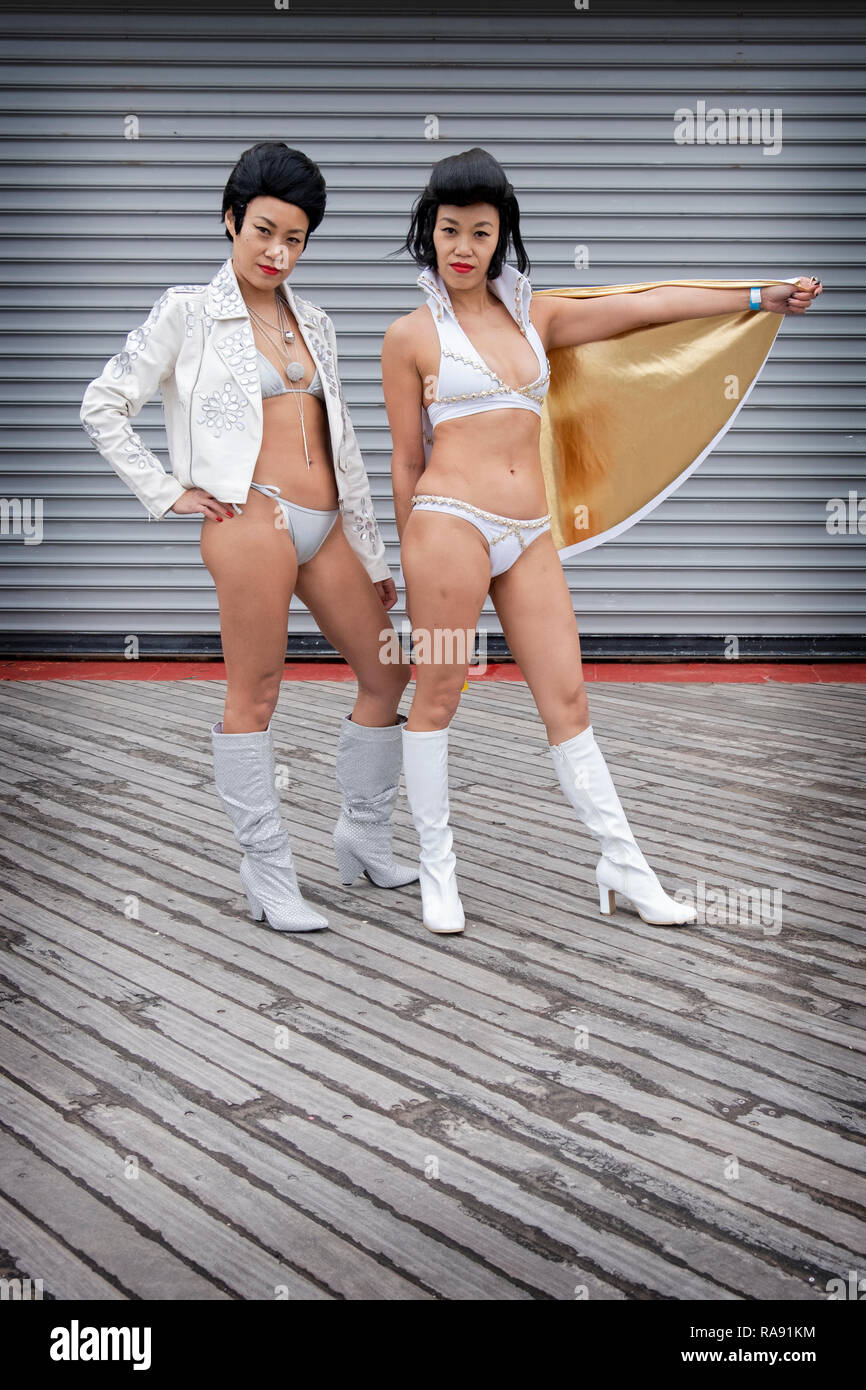 Posed portrait of two Chinese Elvis Presley impersonators in bikinis at the annual Polar Bear Club New Year's day swim in Coney Island, Brooklyn, NYC. Stock Photo