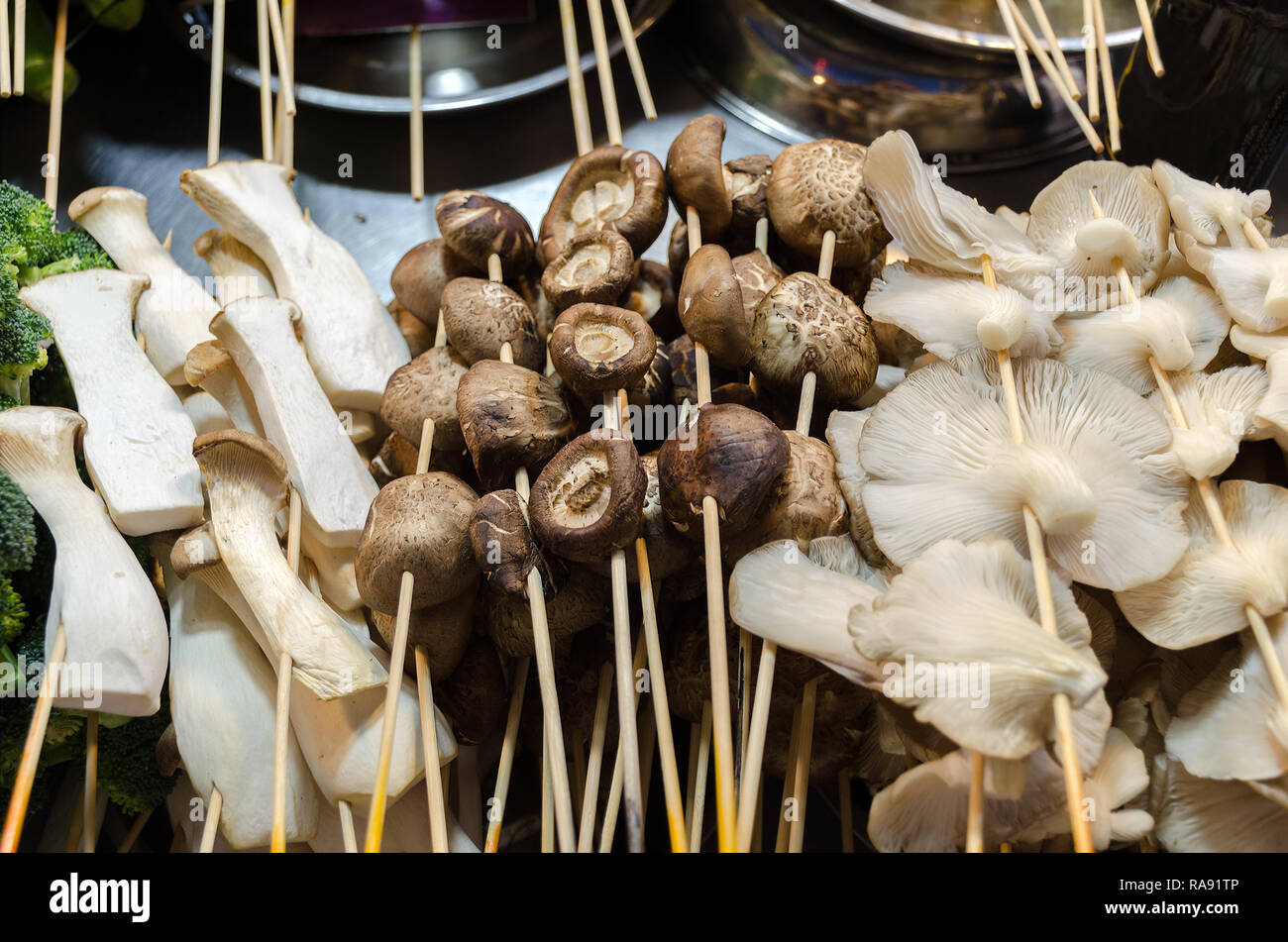 Street food stall with mushroom on sticks, different types porcini