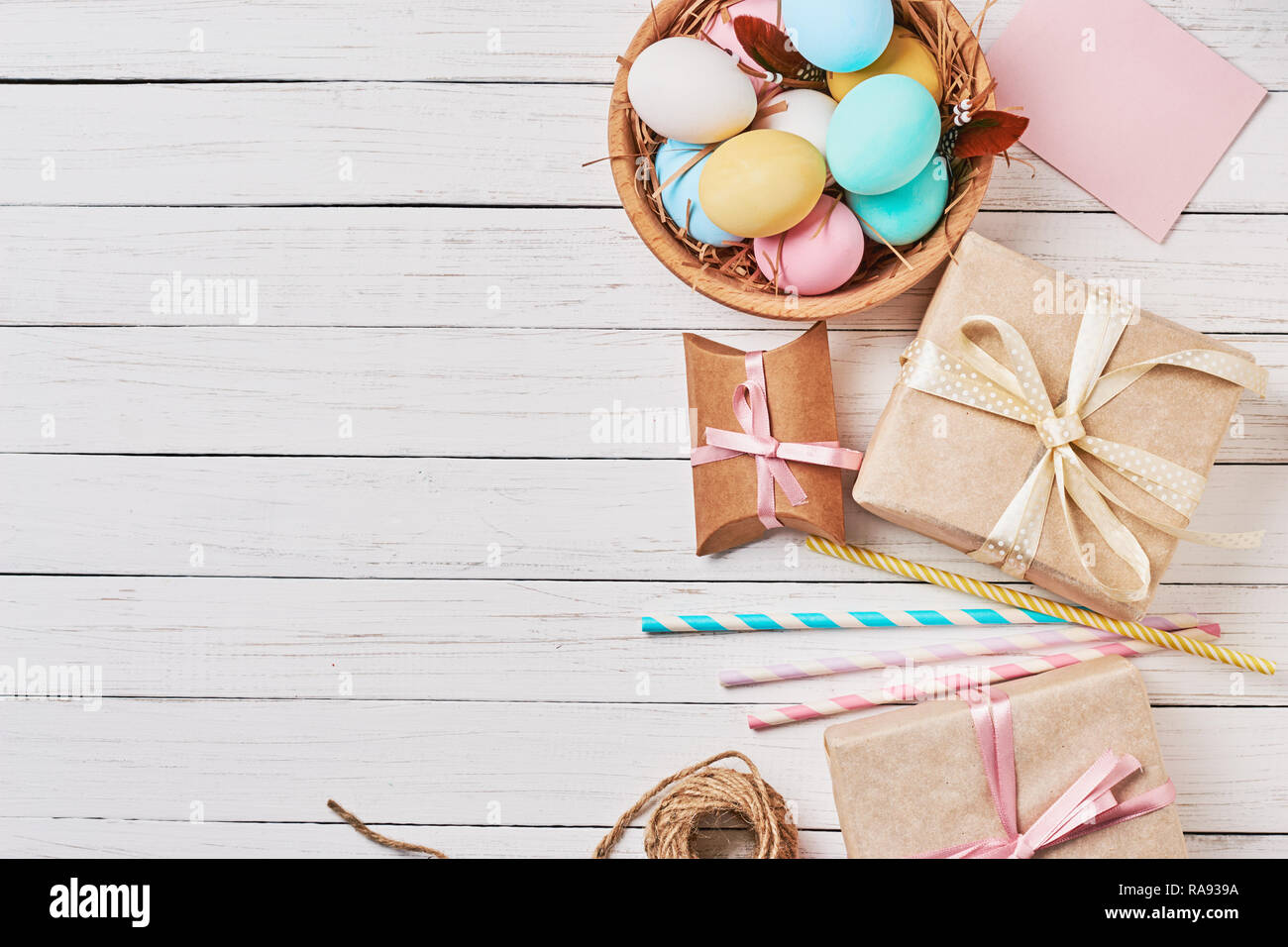 Background with easter eggs, gift boxes and decorations on white, top view with copy space Stock Photo