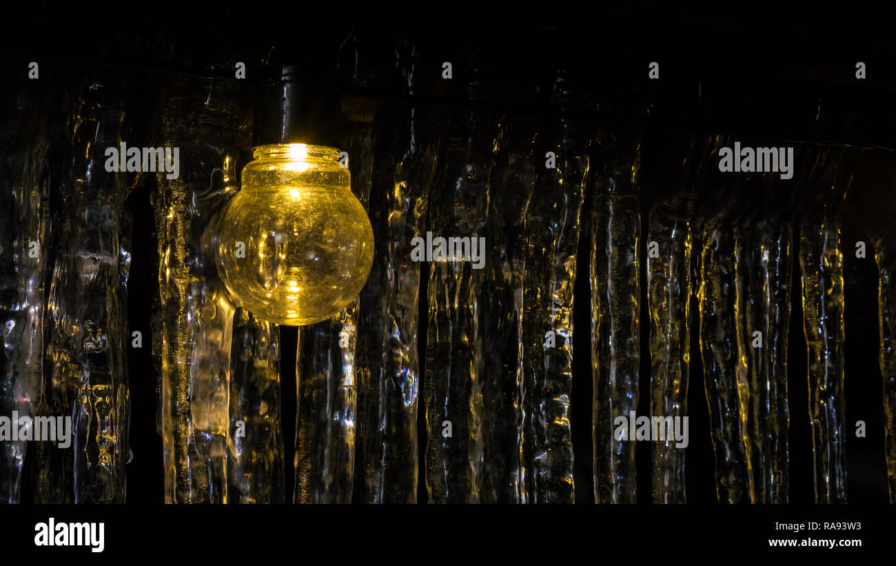 Light bulb and icicles in background Stock Photo