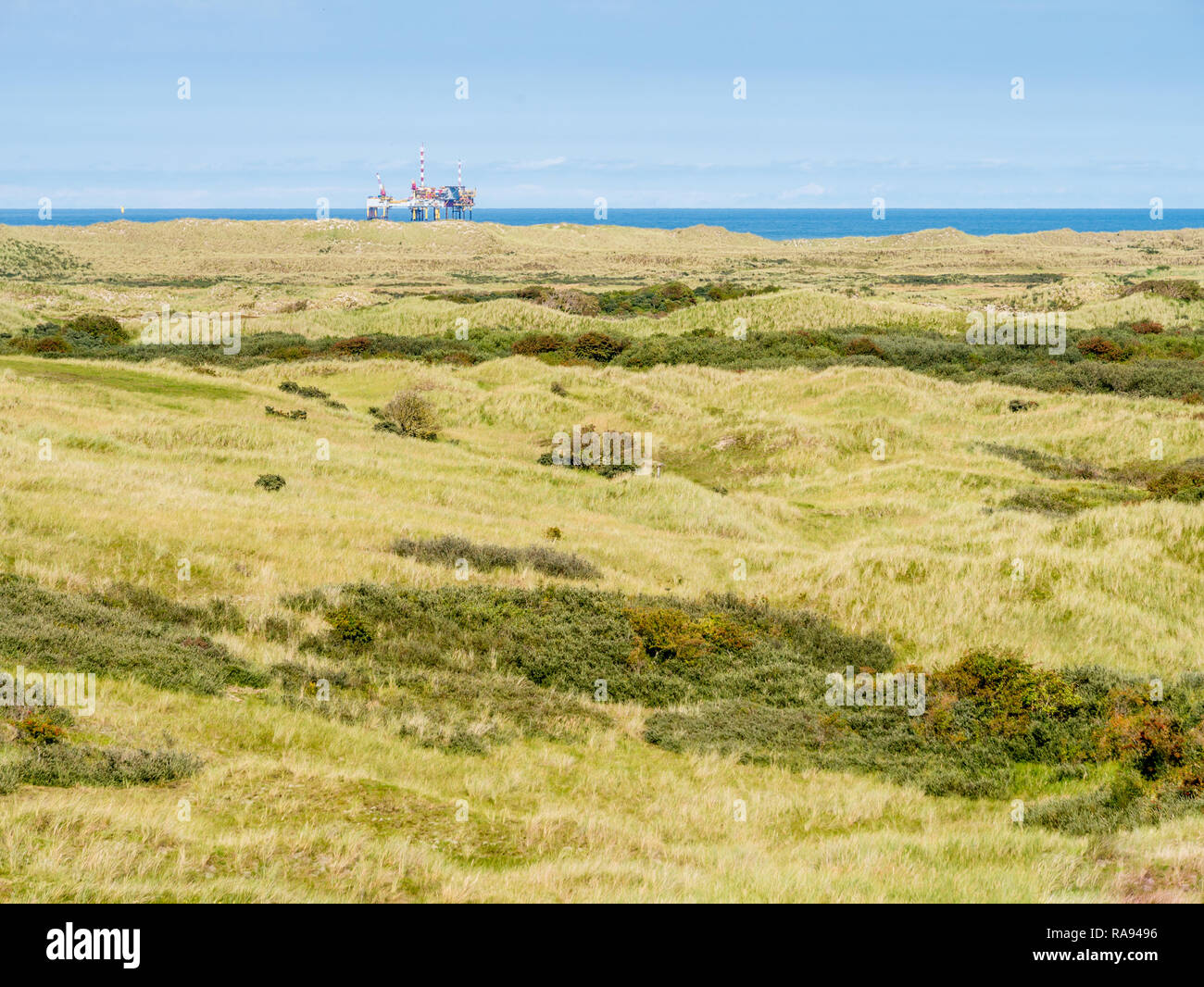 Panorama of dunes of nature reserve Het Oerd and offshore platform in North Sea off coast of West Frisian island Ameland, Friesland, Netherlands Stock Photo