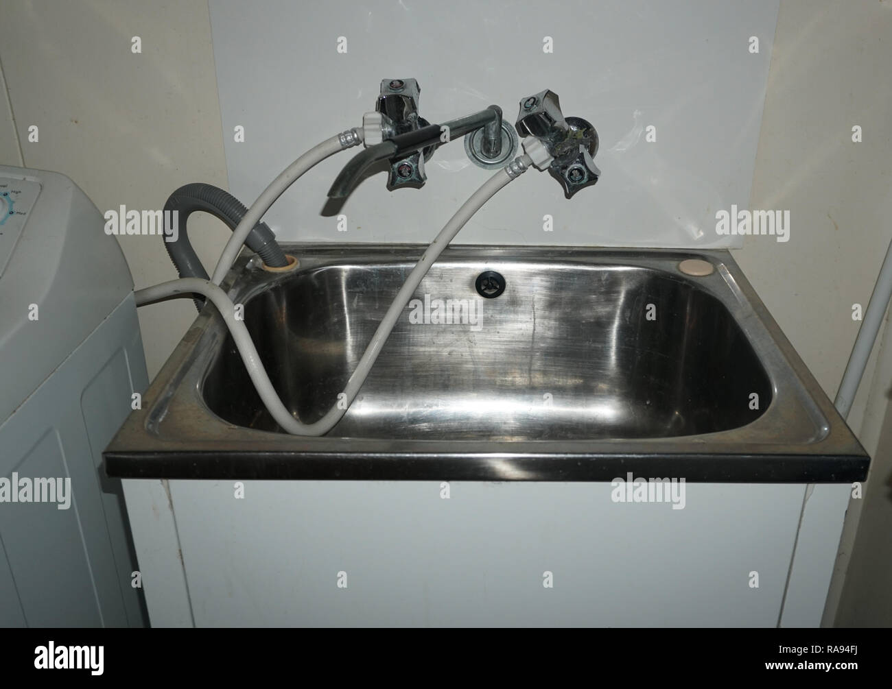 laundry sink with washing machine water hoses Stock Photo Alamy