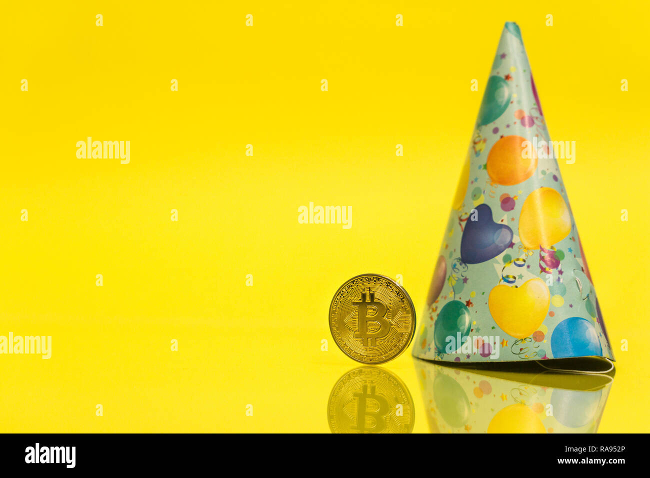 Bitcoin cryptocurrency celebrating birthday - 10 years, coin with birthday  hat behind it, with yellow copy space Stock Photo - Alamy