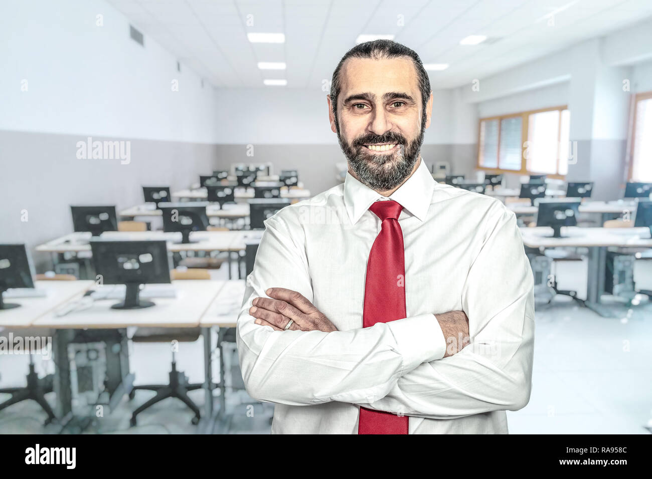 confident teacher and classroom background Stock Photo