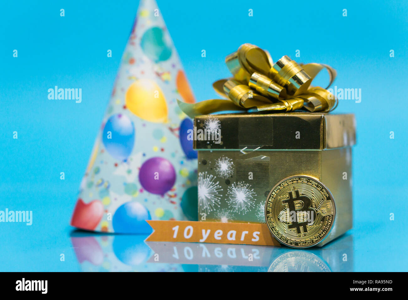Bitcoin 10 year anniversary, coin with birthday golden present and birthday  hat behind it and 10 years sign, copy space Stock Photo - Alamy