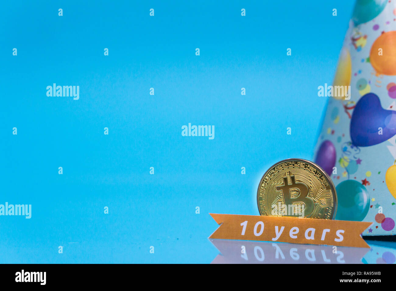 Bitcoin cryptocurrency celebrating birthday - 10 years, coin with birthday  hat behind it, with yellow copy space Stock Photo - Alamy